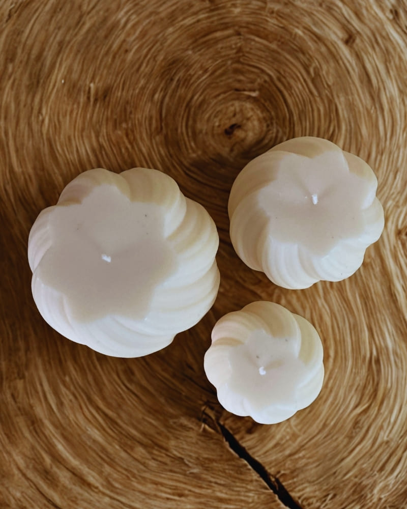 Set di candele decorative artigianali Cosmika viste dall’alto su tavolo in legno, design elegante
