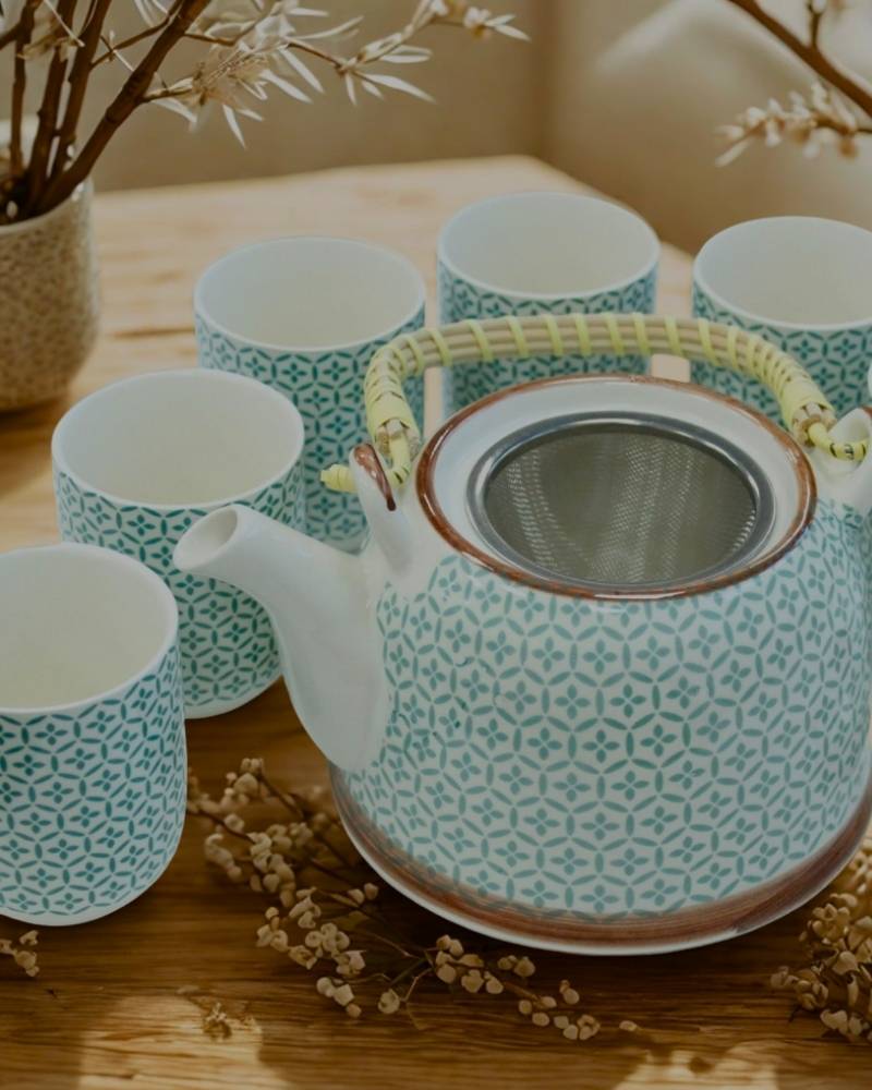 Teiera decorata con 6 tazze abbinate – set tradizionale per infusi e rituali del tè.