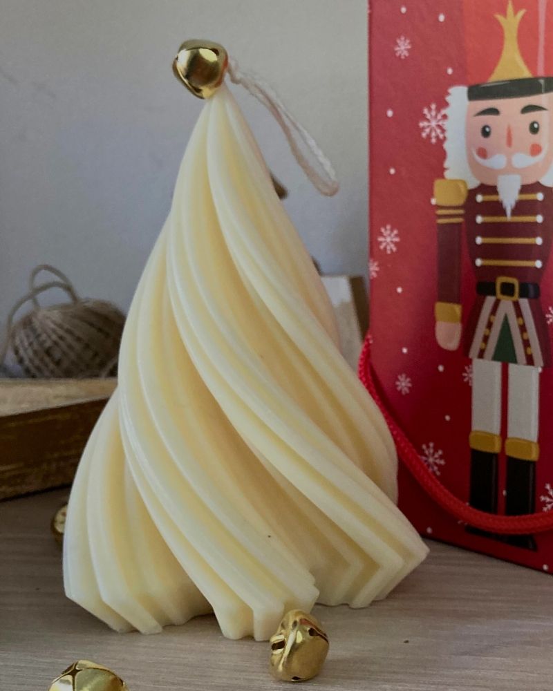 Candela bianco natale con campanellino dorato e confezione regalo natalizia rossa.